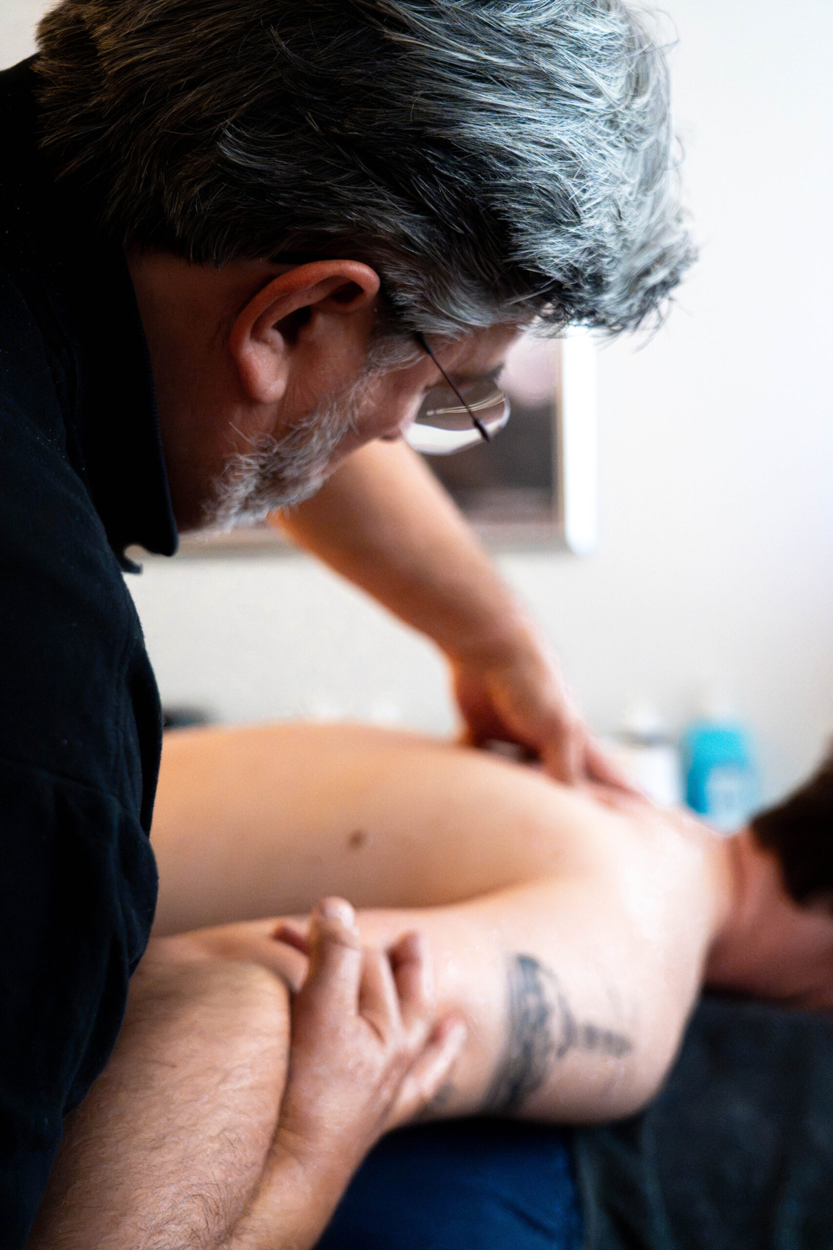 Moreno Giraldi voert een massagebehandeling uit bij een cliënt. Bindweefsel- of myofascialemassage.